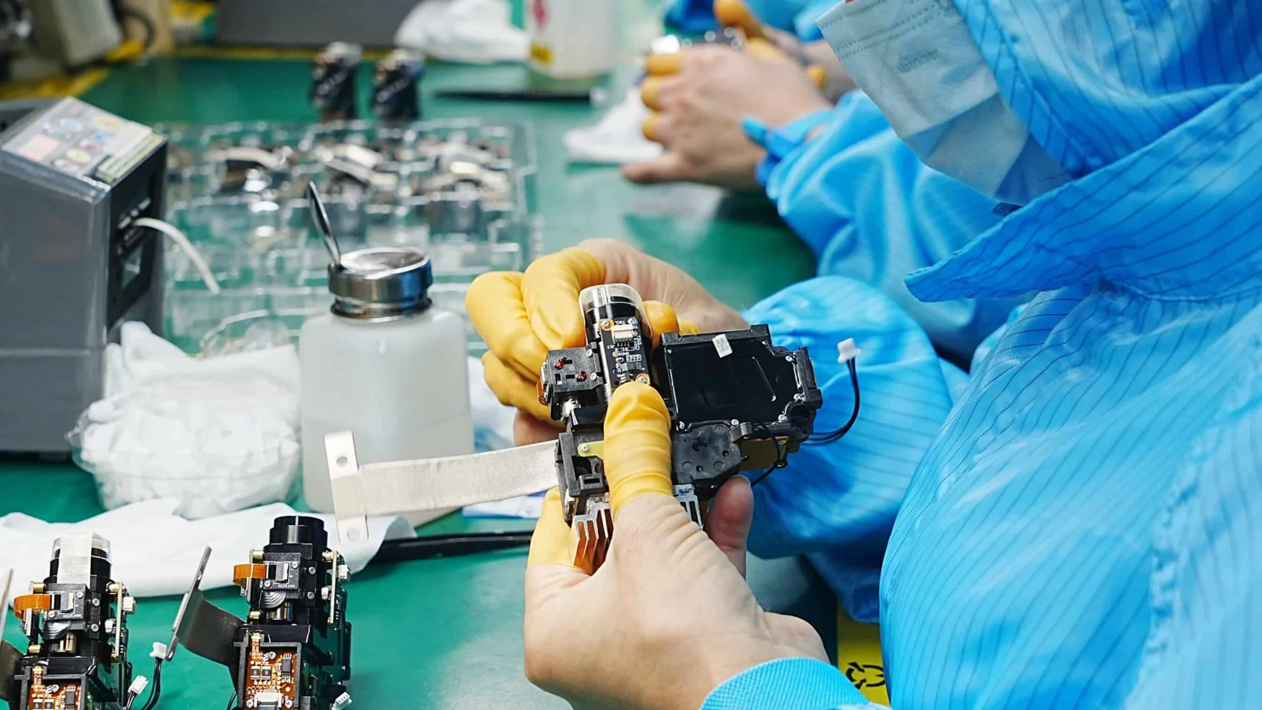 Technician inspecting a projector optical module at a workstation